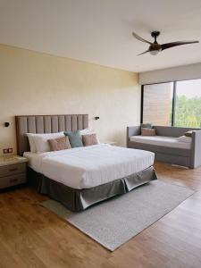 a bedroom with a large bed with a ceiling fan at Gunita Villas in Santo Tomas