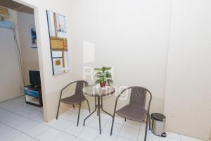 una pequeña mesa con dos sillas y una planta en ella en RedLiving Apartemen Emerald Hill - SR Rooms Tower Green, en Karawang