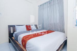 Un dormitorio con una cama y una ventana en RedLiving Apartemen Emerald Hill - SR Rooms Tower Green, en Karawang