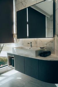 a bathroom with a sink and a mirror at Amigo Hotel Bintulu in Bintulu