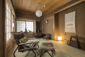 a living room with a chair and a stool at Jokan-en in Honjo