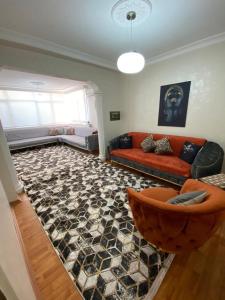 a living room with a red couch and a rug at Ege üniversitesi ve hastanesine çok yakın in Burunabat