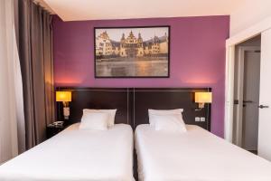 two beds in a hotel room with purple walls at Hôtel Le Mondon Metz in Metz +66 photos