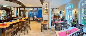 ein Restaurant mit Tischen und Stühlen und eine Bar in der Unterkunft Akzent Hotel Höltje in Verden