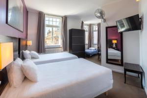 een slaapkamer met een groot wit bed en een spiegel bij Hôtel Le Mondon in Metz