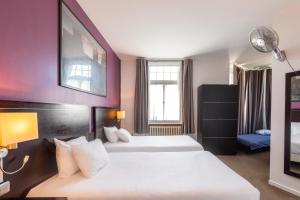 2 Betten in einem Hotelzimmer mit lila Wänden in der Unterkunft Hôtel Le Mondon Metz in Metz