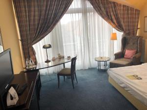 Habitación de hotel con cama, escritorio y silla en Akzent Hotel Höltje en Verden