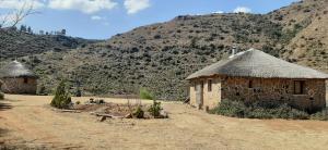 two huts in a field with mountains in the background at Casa Tumi Round Houses. 
