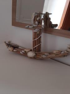 a shelf with seashells and a mirror on a wall at Apartment Karla in Gornji Karin