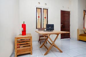 a room with a desk with a computer and a fire extinguisher at SPOT ON Sartika Inn Pati in Pati