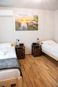 a room with two beds and a painting on the wall at Przystań in Stalowa Wola
