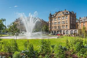 a fountain in a park in front of buildings at Hôtel Le Mondon Metz in Metz