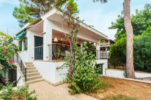 Casa blanca con balcón y árbol en Playa de Palma Beach House, en Playa de Palma