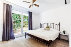 sypialnia z łóżkiem i dużym oknem w obiekcie Playa de Palma Beach House w mieście Playa de Palma