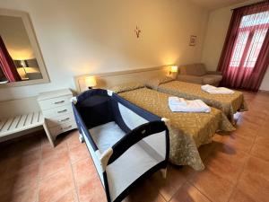 a small room with two beds and a couch at Domus San Bernardino in Verona