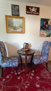 two chairs and a table with a tea kettle on it at San Pablo laguna staycation in San Pablo
