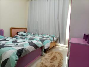 1 dormitorio con 2 camas individuales y alfombra en عجمان, en Ajman
