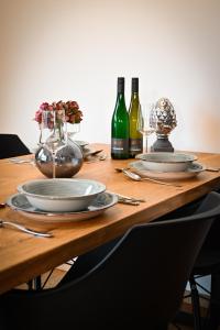 una mesa de madera con platos y botellas de vino en Moselhaus Krieger, en Traben-Trarbach