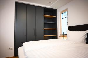 1 dormitorio con cama blanca y armarios negros en Moselhaus Krieger, en Traben-Trarbach