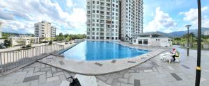 uma pessoa a passear um cão ao lado de uma piscina em Ipoh Meru - Spacious - 20mins Ipoh Town - 20mins Tambun - Pool View - Near Bus Station - Free 3 Parking by Happy Homestay em Ipoh