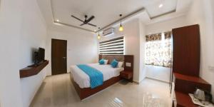 a bedroom with a bed with blue pillows in it at Heaven Stay in Port Blair