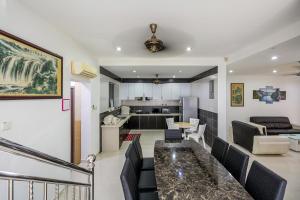 丹絨武雅的住宿－Seaside Private Bungalow, Tg Bungah，一间带桌椅的客厅和一间厨房