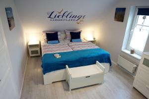 um quarto com uma cama grande e um cobertor azul em FeWo Nordseeflair OG - Wiarden em Wiarden