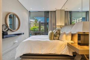1 dormitorio con 1 cama grande y espejo en Luxury Villa in V&A Waterfront, en Ciudad del Cabo