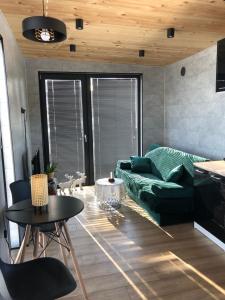 sala de estar con sofá verde y mesa en Green Hill Apartment - Domek na Wyłączność en Leśnica