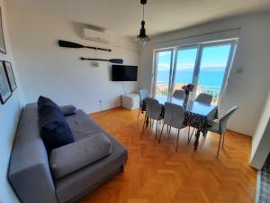 a living room with a couch and a table and chairs at Apartments Novum in Novi Vinodolski