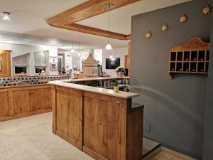 cocina grande con armarios de madera y encimera en Hotel Garni Sottobosco, en Dimaro