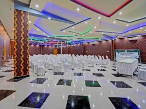 - une salle de banquet avec des tables et des chaises blanches dans l'établissement OYO 91997 Edhotel Smk Models Syariah, à Pasanggaran
