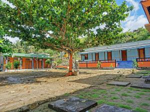 a tree in a yard in front of a building at OYO 91988 Azka Homestay Klayar in Pacitan