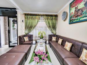 - un salon avec un canapé et des fleurs sur une table dans l'établissement OYO Life 91994 Sawerigading Jatinangor Syariah, à Sayang