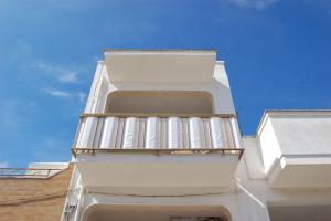a white building with balconies on the side of it at Appartamento Sunny by ThePuglia in Torre Lapillo