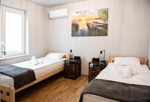 two beds in a room with a picture on the wall at Przystań in Stalowa Wola