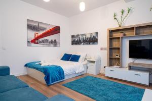 a bedroom with a bed and a flat screen tv at 21 Residence Studio in Bucharest