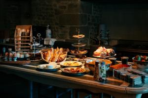 una mesa con muchos platos diferentes de comida en ella en Le Clos Violette et Le 11 D'Aglaé - Appart' hôtel Design de Luxe en LʼIsle-sur-la-Sorgue