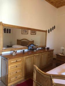 ein Schlafzimmer mit einem großen Spiegel und einer Holzkommode in der Unterkunft Παραδοσιακό Αρχοντικό με Τζάκι in Valtessiniko