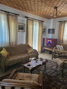 uma sala de estar com um sofá e uma mesa em Παραδοσιακό Αρχοντικό με Τζάκι em Valtessiniko