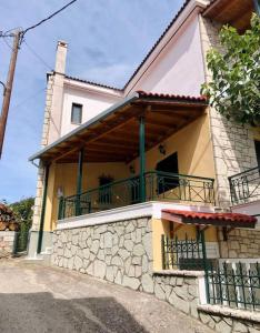 a house with a balcony on the side of it at Παραδοσιακό Αρχοντικό με Τζάκι in Valtessiniko 
