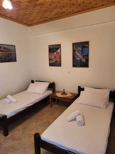2 Einzelbetten in einem Zimmer mit einem Tisch in der Unterkunft Παραδοσιακό Αρχοντικό με Τζάκι in Valtessiniko