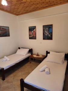 two twin beds in a room with a table at Παραδοσιακό Αρχοντικό με Τζάκι in Valtessiniko 