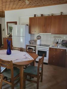 a kitchen with a table and a white refrigerator at Παραδοσιακό Αρχοντικό με Τζάκι in Valtessiniko 