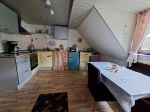 eine Küche mit einem Tisch in der Mitte eines Zimmers in der Unterkunft Ferienwohnung Sonja mit Garten und Freisitz in Steinwiesen