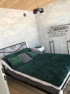 1 dormitorio con 1 cama grande con manta verde en Green Hill Apartment - Domek na Wyłączność en Leśnica