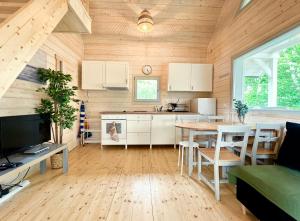 a kitchen and dining room in a wooden house at Nadmorska Perełka w Rusinowie in Rusinowo