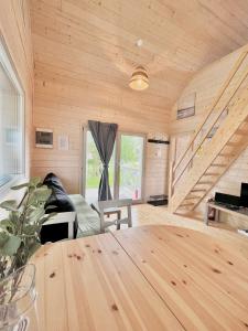 a wooden room with a table and a staircase at Nadmorska Perełka w Rusinowie in Rusinowo