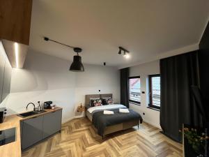 a bedroom with a bed and a desk and windows at Apartamenty Warowna 2 in Pszczyna