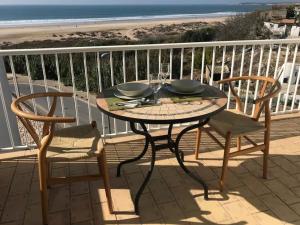 una mesa y 2 sillas en un balcón con vistas a la playa en Chorrillo III, en Conil de la Frontera